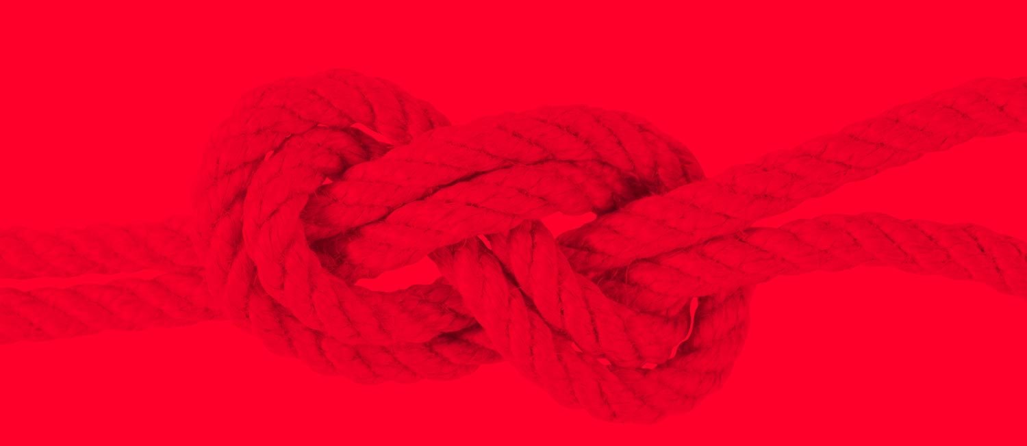interdependence shown with four strands looped into an infinity shape on a red background