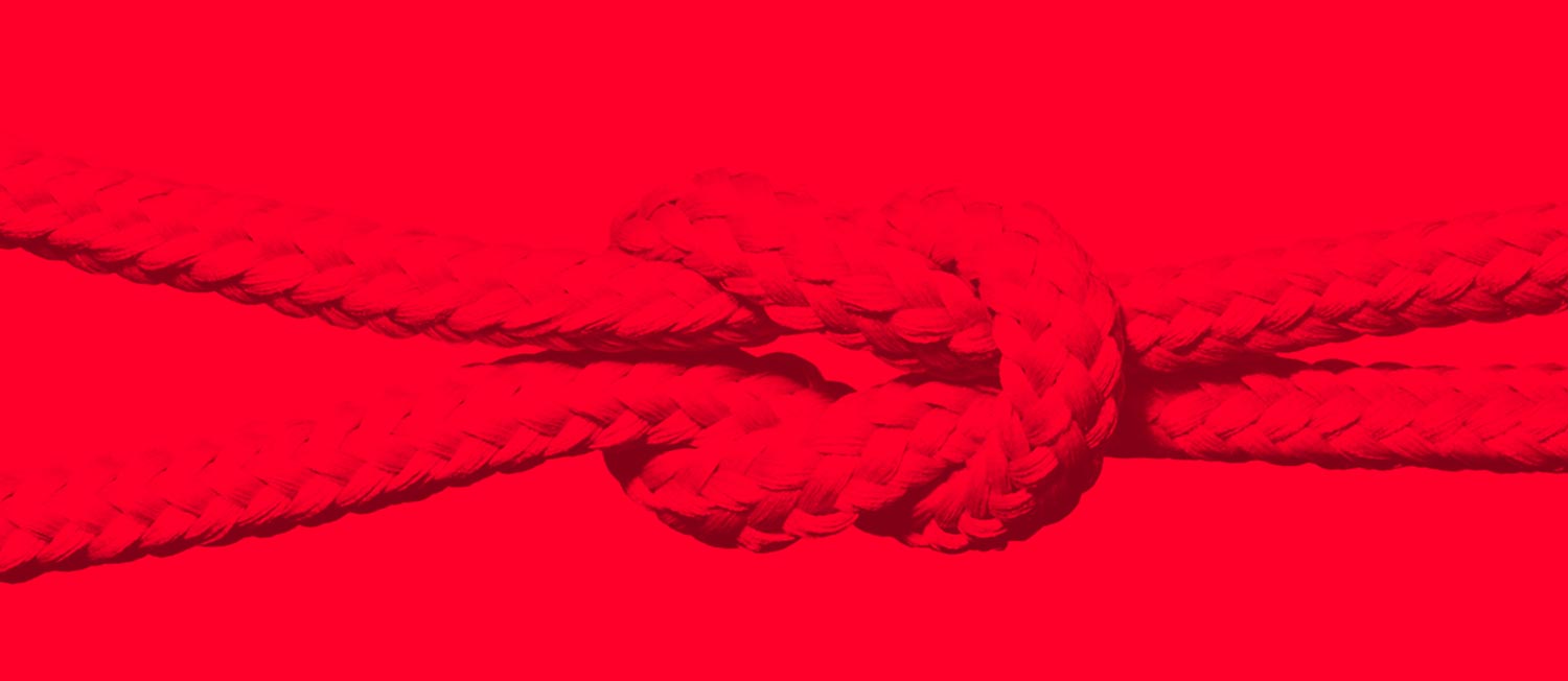 interdependence shown by two strands tied into each other on a red background 